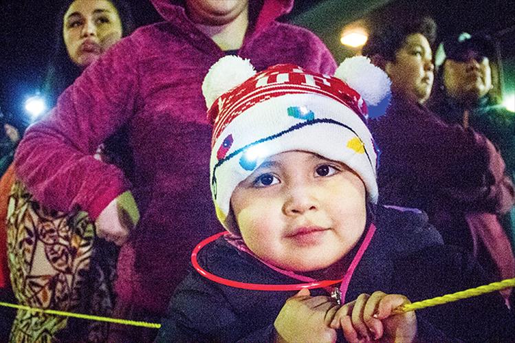 A little parade goer hangs tight to his candy cane.