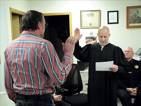 Outgoing Ronan Municipal Judge Justin L. Bartels swears in his replacement, Randy Melton, last week.