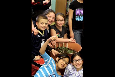 Some of Anna Luke’s after-school club class, Colton Graham, Ashlie Welker, Hannah Rowe, Mikayla Caye and Sariel Sandoval, pose next to a pot filled with soon-to-be carrots.