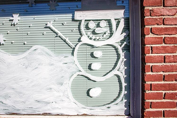 The closest local residents have gotten to a snowman recently is this happy guy painted on a local window.