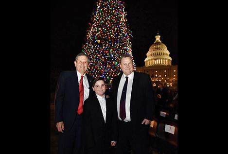 Senator Steve Daines, Bozeman sixth grader Ridley Brandmayr and Senator Jon Tester pose in front of the lit U.S. Capitol buliding’s Christmas tree from Montana.