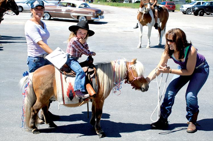 A miniature horse and cowgirl join the parade line at Arlee High School.