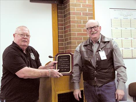 Rich Wiebke, left, receives a plaque from county commissioner Dave Stipe during a county employees’ luncheon on Tuesday, Dec. 19. 