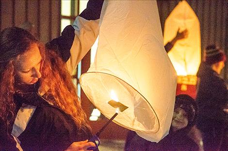 Student Aurrora Watkins lights one of 80 lanterns.