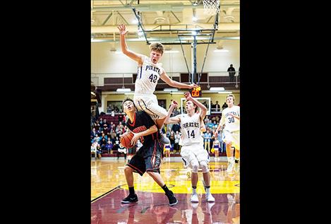 Ronan Chief Randy Finley, left, is bonked by Polson Pirate Sam Schultz as Finley heads for the hoop.