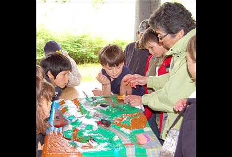 Flathead Lakers volunteer Libby Smith demonstrates and discusses nonpoint source pollution to students.The enviroscape model provided a powerful visual demonstration of how water and pollution flow through a watershed.