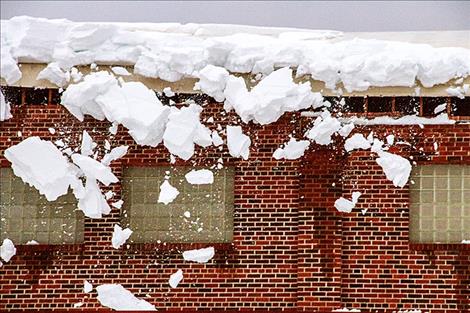 : Snow falls from the school’s roof on Saturday afternoon.