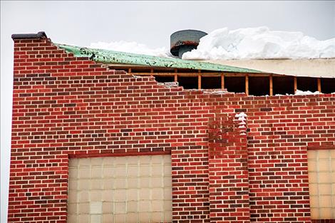  A section of the brick wall is damaged from the snow.