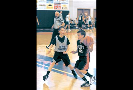 Robin Erickson defends a charge from Colton Graham as referee Gale Decker looks on.