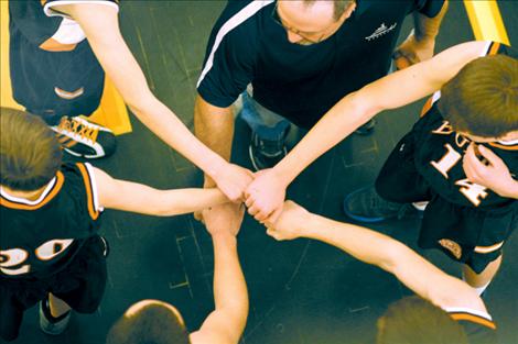 Eureka’s starting five and coach put their hands in for a cheer just before their first game of the tournament.