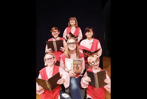 Pictured here, evil accountants bone up on the Elves and the Shoemaker story for their big performance. Clockwise from top: Jocelyn Anciaux, Chenoa Villegas, Finn Goddard, Hailey Stocking, Serious Curry and Autumn Skillicorn are joined by 115 students, divided into two separate casts. Local kindergarten through eighth grade actors are teamed with three veteran Polson High School performers.