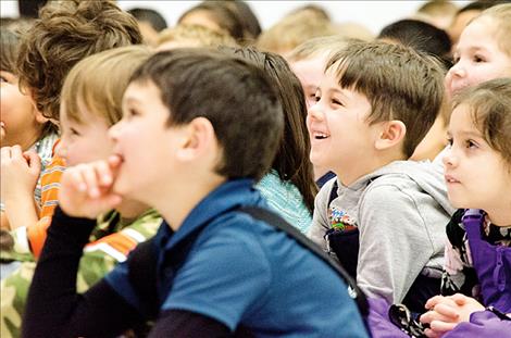 Children laugh when Spencer gets to the funny part of a story.