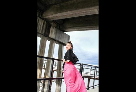 Mariah Waugh leans on the railing  under the Polson  bridge.