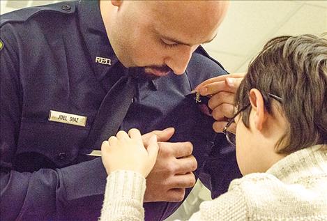 Ronan Officer Joel Diaz gets his badge pinned on by his son.