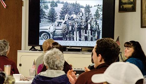  Volunteers and family members watch a slide show with a photo from around 1978 when Drew Hendrickson first joined the department. He is in the top row, far right.