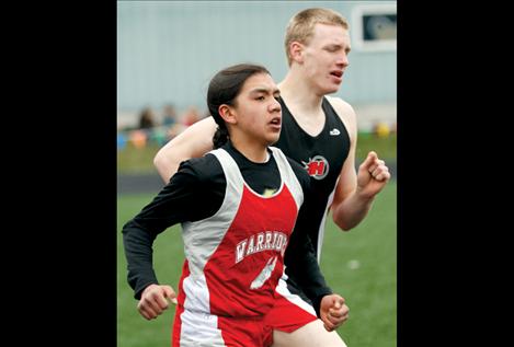 Zach Felsman keeps pace with a Hot Springs runner at the Ronan meet last week.