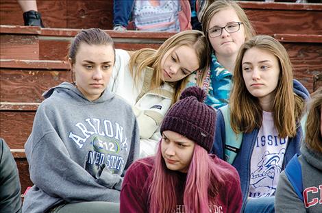 Somber faced students from St. Ignatius High School sit in the schools football bleachers after walking out of school to show respect for the students lost in the Florida school shooting
