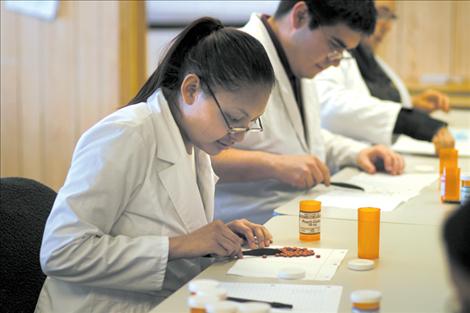 Kicking Horse pharmacy tech students sort and count pills in class. 