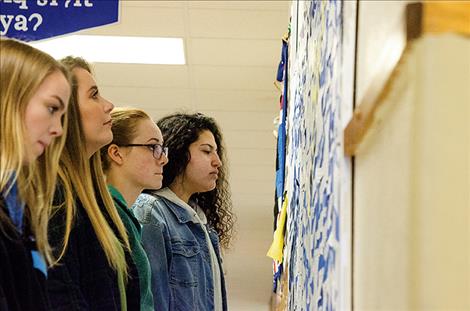 Sophia Tolbert, Leila Marsh, Brooklinn Hunt, and Addison Arlint read comments on a bulletin board where students anonymously posted comments about their experiences with suicide and suicide prevention. 