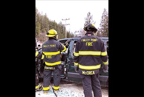 Firefighters Chuck Campbell and Dennis McCrea  practice using the Jaws of Life.