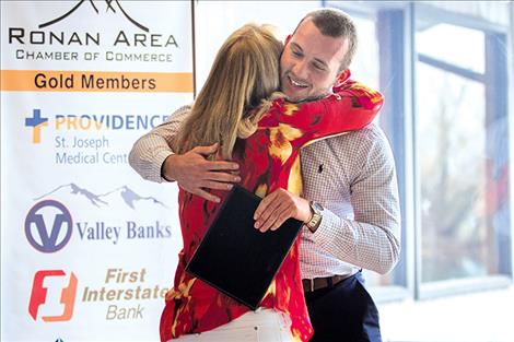 Robbie Gauthier receives a hug and the Ambassador of the Year Award.