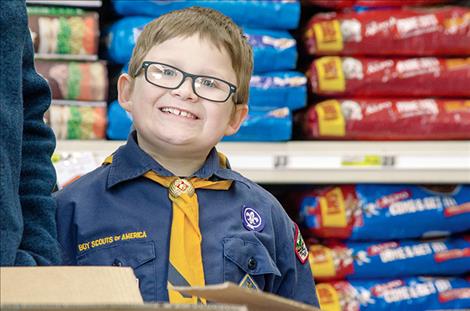 With a smile, Cub Scout Elijah Bell, 8, asks people to donate.