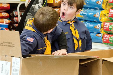 Cub Scout Tyler Miller, 8, is impressed with the amount of items people donated to the troop’s food drive on Saturday. 