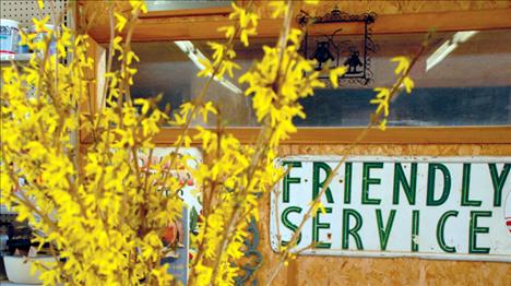 A vase of forsythia and a friendly service sign tell a lot about South Shore Greenhouse.