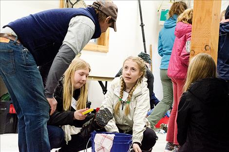 Research specialist Phil Matson talks to students about the importance of cleaning and drying all things brought to water bodies including boots. 