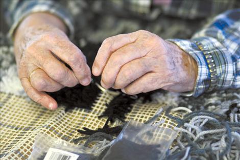 Doris Nordyke creates a gray blanket using a hook and yarn. Once completed, the blanket will be a picture of a running horse in grey and black relief.