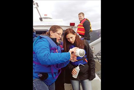 Education coordinator Holly Church shows SKC STEM Academy student Veyanna Curley plankton filtration on Flathead Lake.  