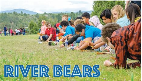 Students add up how many pounds of food they found while pretending to be bears along the Flathead River.  
