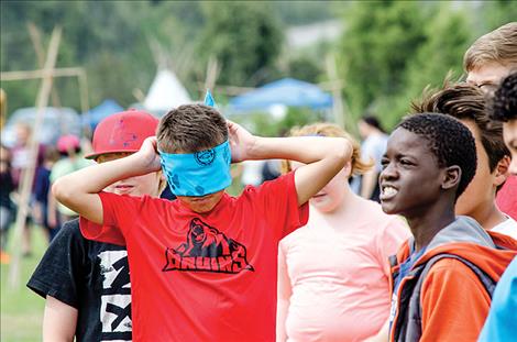 A student pretends to be a blind bear looking for food during an an activity. 