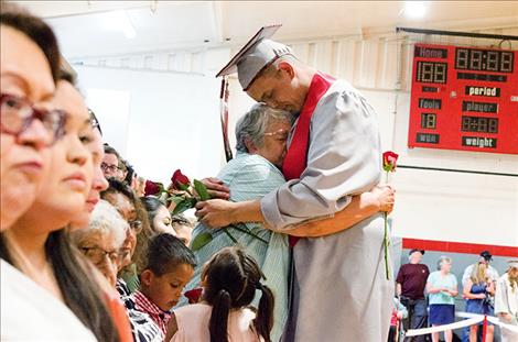 Rory Bird hugs a family member during the rose ceremony where graduates honor important people in their lives.