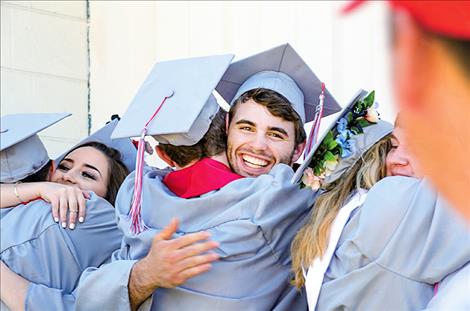 George Shick hugs a fellow classmate after graduating.