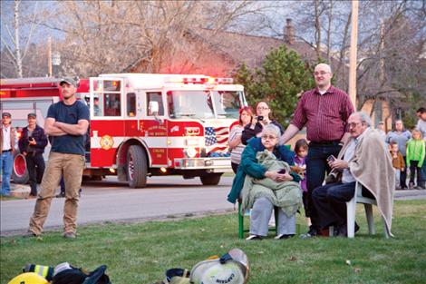 Homeowners Barbara and Lucky Donnegan are comforted by neighbors as they watch a fire consume their home of 28 years.