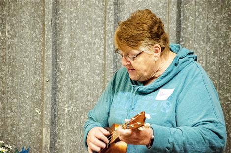 Volunteer Marilynn Tanner plays the ukulele at the celebration.