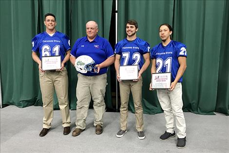 Arlee football players, Rory Bird (61), George Shick (72) and Will Mesteth Jr. (21) stand for a photo with Coach Chuck Forgey.