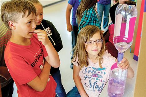 Arinna Schall gives a demonstration of her tornado in a bottle to fellow students.