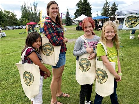 Phoebe Webb joins young shoppers in displaying the new Ronan Farmers Market tote bags.