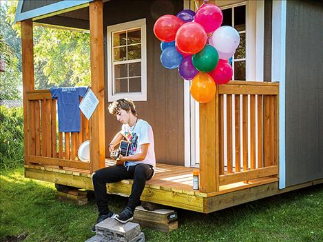 Iliff plays the guitar on the porch of his gifted recording studio during a celebration picnic held in his honor. 