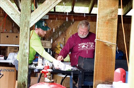 Volunteer  Firefighter Ray Frey cooks hamburgers under a protected shelter. 