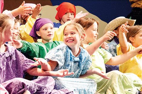 Actors playing roles as the younger daughters set the farm scene on stage.