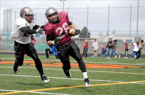 University of Montana junior running back Jordan Canada escapes a teammate during the Grizzlies’ spring scrimmage held Saturday at Ronan High School’s Laverne Parrish Field.