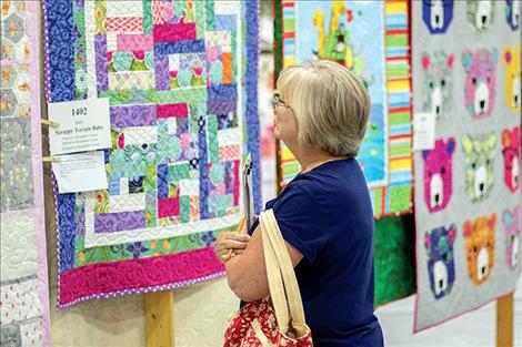 A visitor to the quilt show studies the details of quilt number 1402.