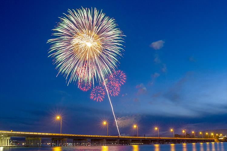 July 4th fireworks rise above the lights of Polson's Veterans Memorial Bridge.