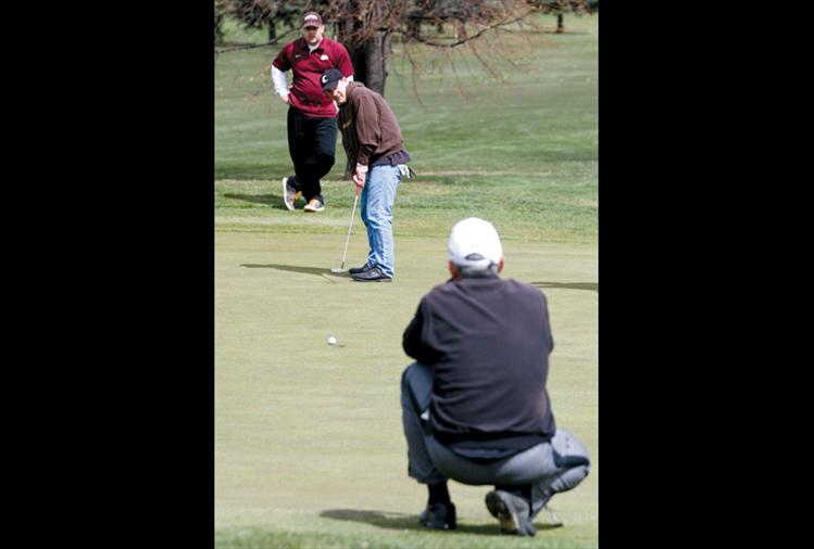 Chad Komlofske of Polson watches his putt roll in as Billy Fisher of Missoula and Ron Fricker of Polson look on.