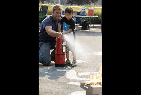 Ezra Choate helps Polson firefighter Blake Holman put out a grease fire.