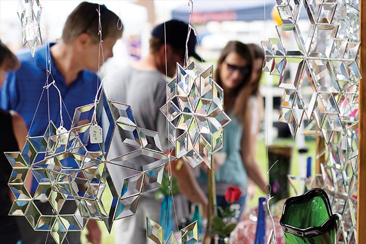 Glass snowflakes hang from an art vendor's booth.