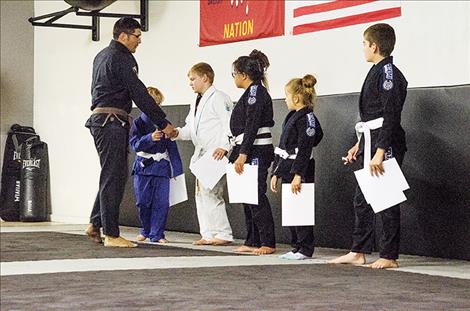 Instructor Justin Dumontier congratulates the students for finishing the summer Jiu-Jitsu program.